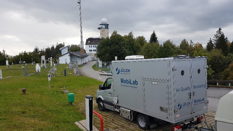 Mobile laboratory (MobiLab) with the Hohenpeissenberg observatory in the background. Mobile laboratory (MobiLab) with the Hohenpeissenberg observatory in the background.